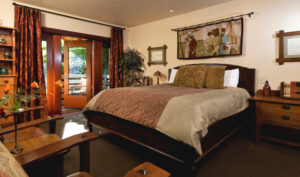 Room 1 with King Bed, night stand, 2 Chairs with Table. French Doors are Open to Patio