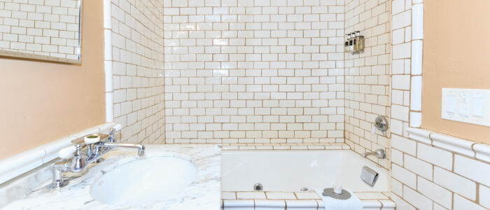 Room 1 Bathroom Combination Tub and Shower with Subway Tile, Marble Counter Sink with Vanity Mirror