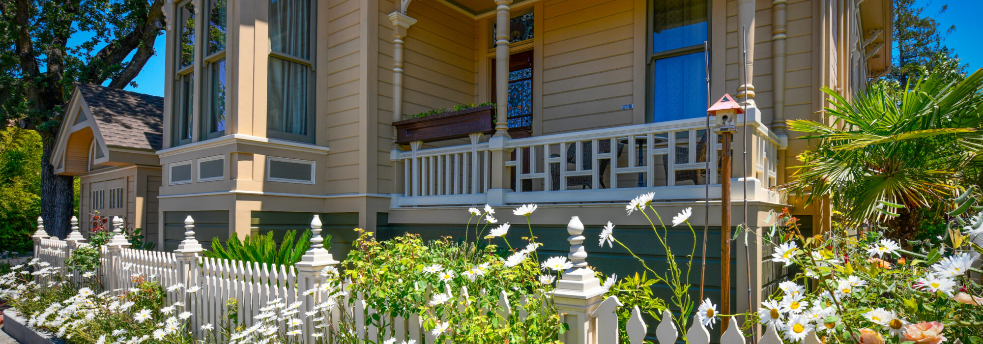 Historic Queen Anne Eastlake Front Porch and Tower Fronting on Jefferson Street. Room 10's Porch/Balcony Sits 5 Feet Above Victorian Garden with Flowers , Palms and Cycads.