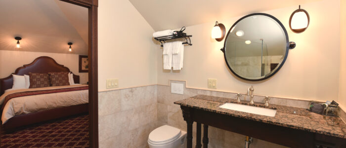 Room 12's Bathroom is Victorian Styled, but Features modern Large Porcelain Tiled Wainscoting, and Wall Mounted Toilet off of the Main Room.