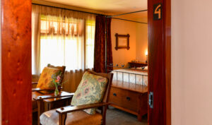 Doorway to Room 4 King Bed and 2 Chairs in Sitting Area