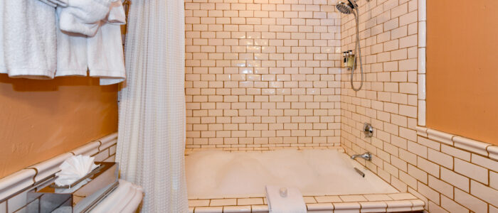 Room 8 Shower, Jetted Jacuzzi Tub Combination with White Subway Tiles. Wall Rack Full of Towels, Tub Full of Bubbles